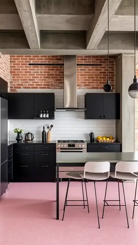 An industrial-chic kitchen with pink terrazzo flooring, matte black cabinets, a stainless steel range hood, and minimalist bar stools.