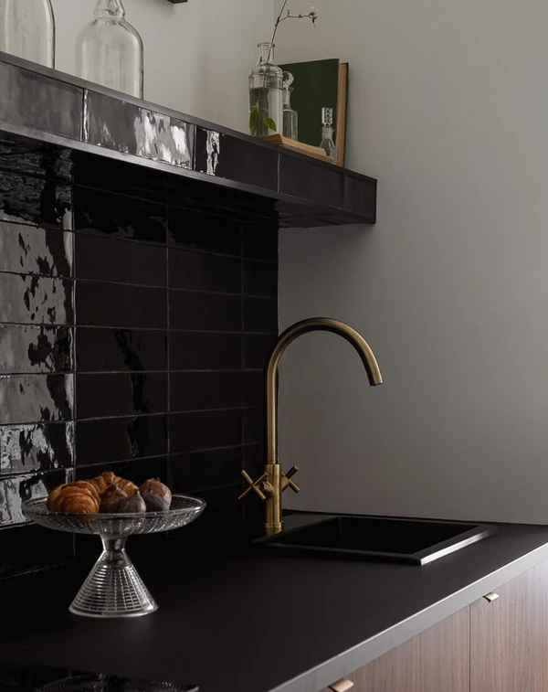 Black Tile Backsplash with Brass Accents