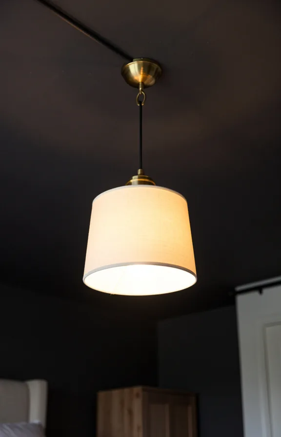 Bedroom ceiling detail showing pendant light fixture hanging from removable hook