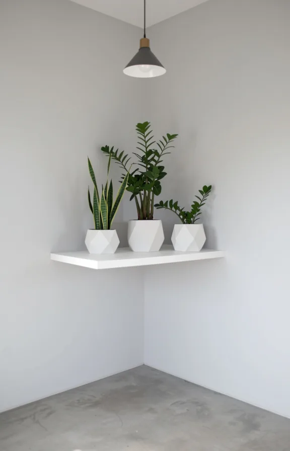 Corner of a minimalist apartment with one tall white floating shelf holding three geometric ceram