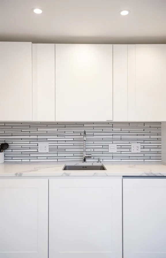 linear black and white peel and stick tile pattern on backsplash