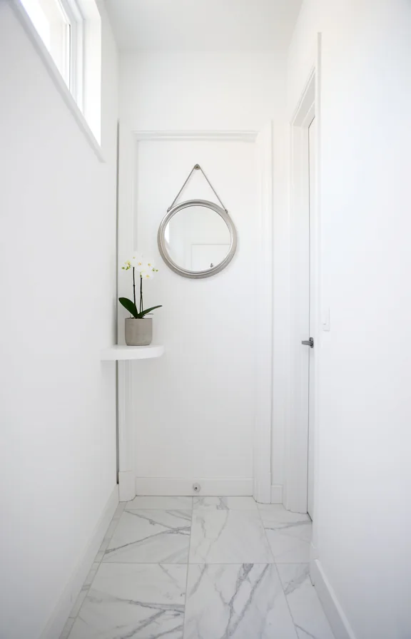 polished light gray marble tile floor, white wooden door frame