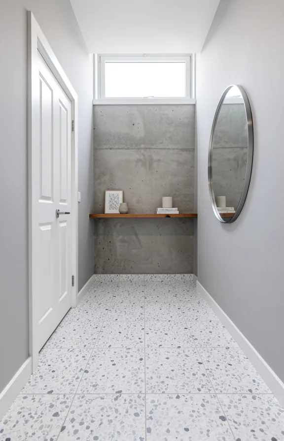 pale gray walls, white painted wooden door, round mirror with polished stainless frame
