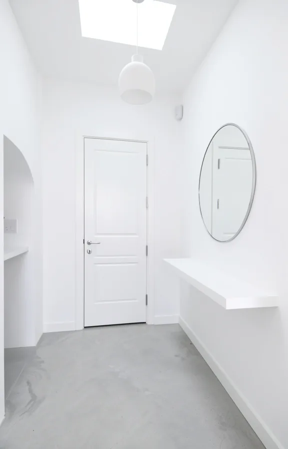 white wooden door with chrome hardware, light gray polished concrete flooring