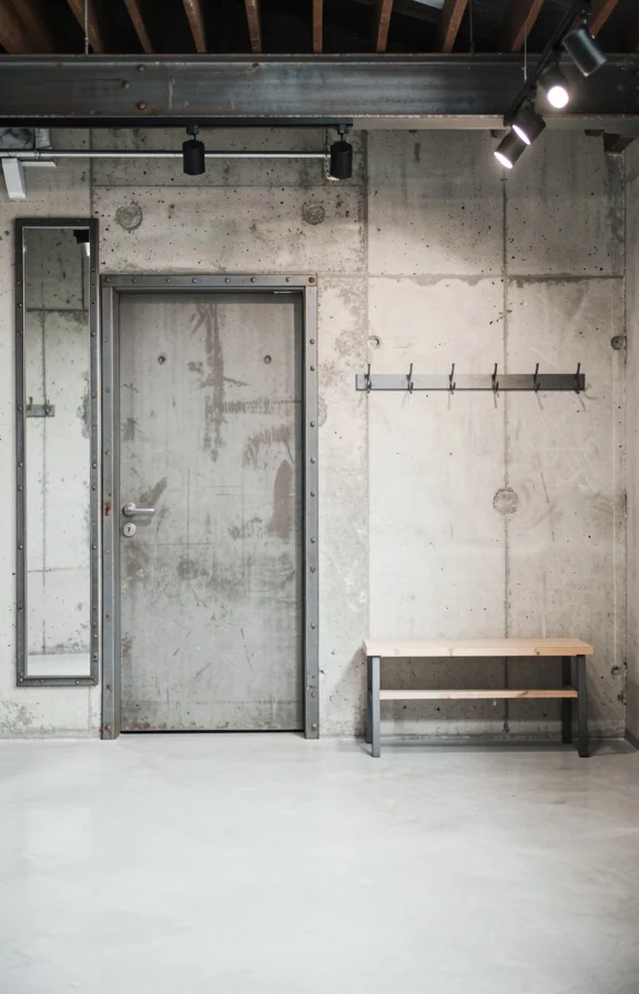 Full entry view with raw concrete accent wall behind door