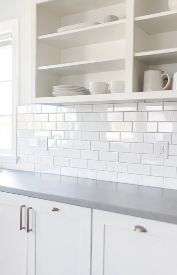 Full kitchen wall waist-level shot with bright white subway tiles covering backsplash and lower w