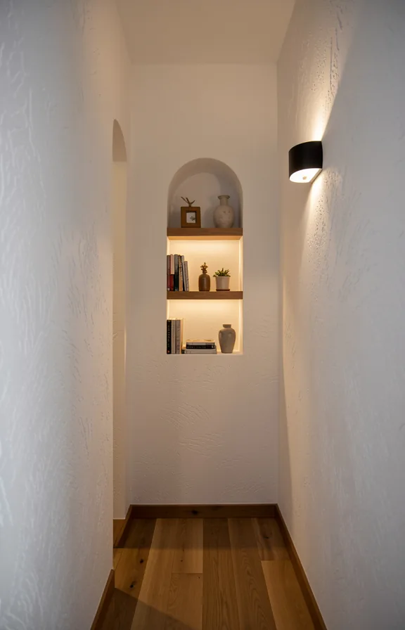 Narrow passage with small recessed niche in wall displaying decorative objects or books