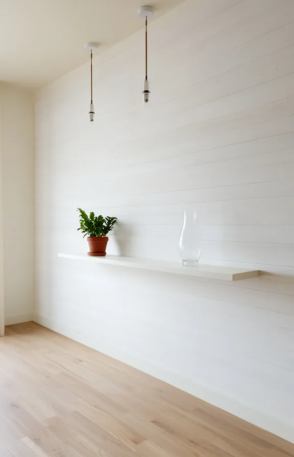 Three-quarter view of white shiplap accent wall in studio apartment