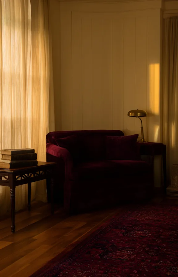 3/4 view of a living room corner with a deep burgundy velvet sofa anchoring the space
